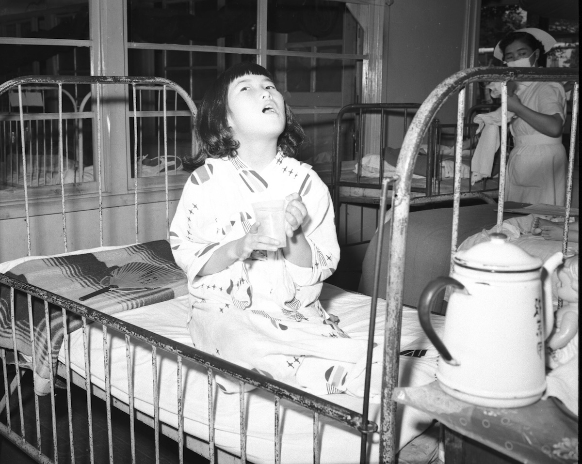 Child gargling broth in a Japanese hospital during the Asian flu pandemic, 9 August 1957. Otis Historical Archives National Museum of Health and Medicine (CC BY 2.0).