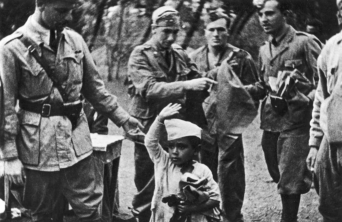 A young Ethiopian performs the fascist salute for some Italian soldiers, c. 1936-37. Narodowe Archiwum Cyfrowe. Public Domain.