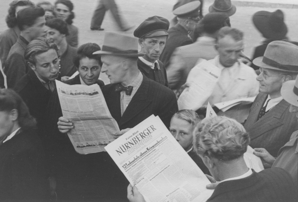 People gather to read a special edition of the Nürnberger newspaper reporting the sentences handed down by the International Military Tribunal, 1 October 1946. US Holocaust Memorial Museum, courtesy of Gerald Schwab.