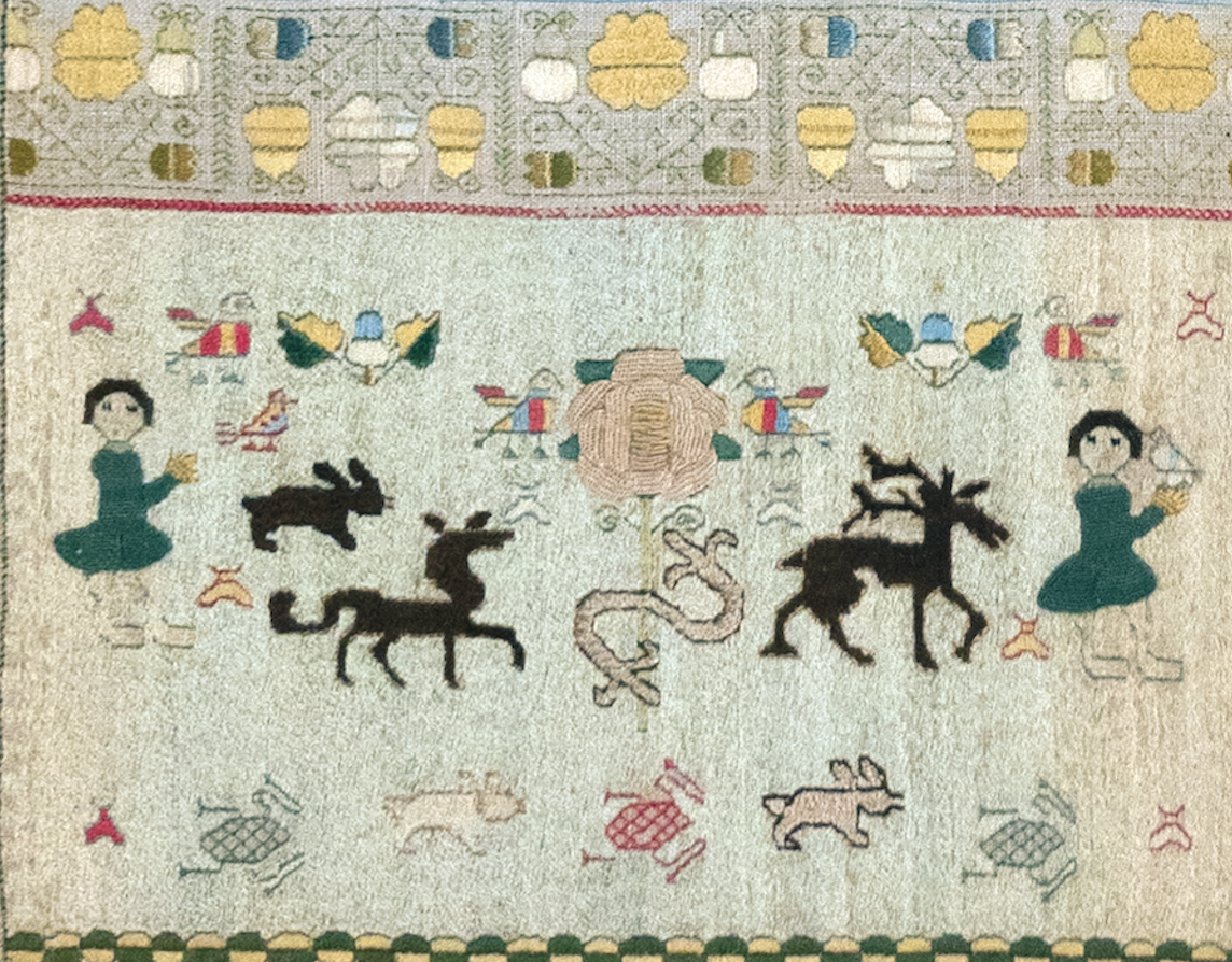 Martha Collymore’s sampler, detail showing her inscription (bottom) below the rose flanked by birds, Barbados, 1771. Royal School of Needlework.