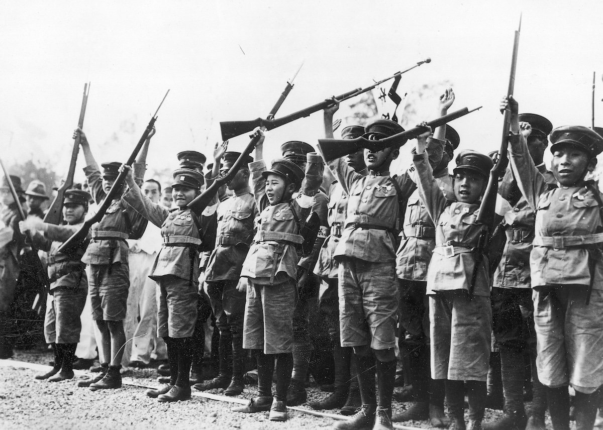 Japanese children in uniforms raise their arms to salute emperor Hirohito, c. 1932. Narodowe Archiwum Cyfrowe. Public Domain.