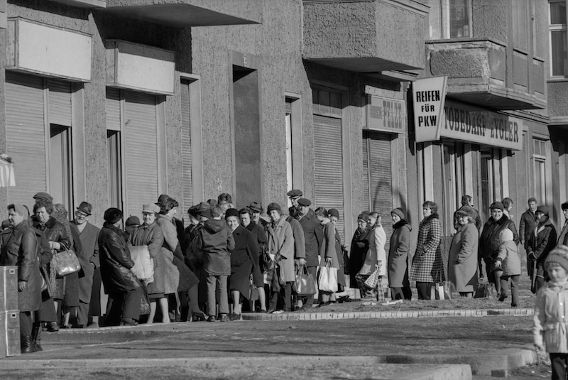 A queue outside a shop in East Berlin, by Heinz Bauman, c. 1974-75. ETHBIB.Bildarchiv. Public Domain.