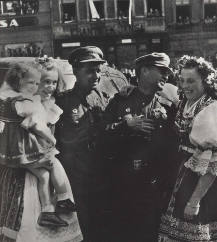 Two Red Army officers pose with Czechoslovakian women in national costume, May 1945. Moravian Library in Brno. Public Domain.