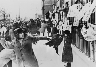 Students hurl rocks at the US embassy in Moscow to protest the Vietnam War whilst Soviet police look on. US Information Agency. Public Domain.